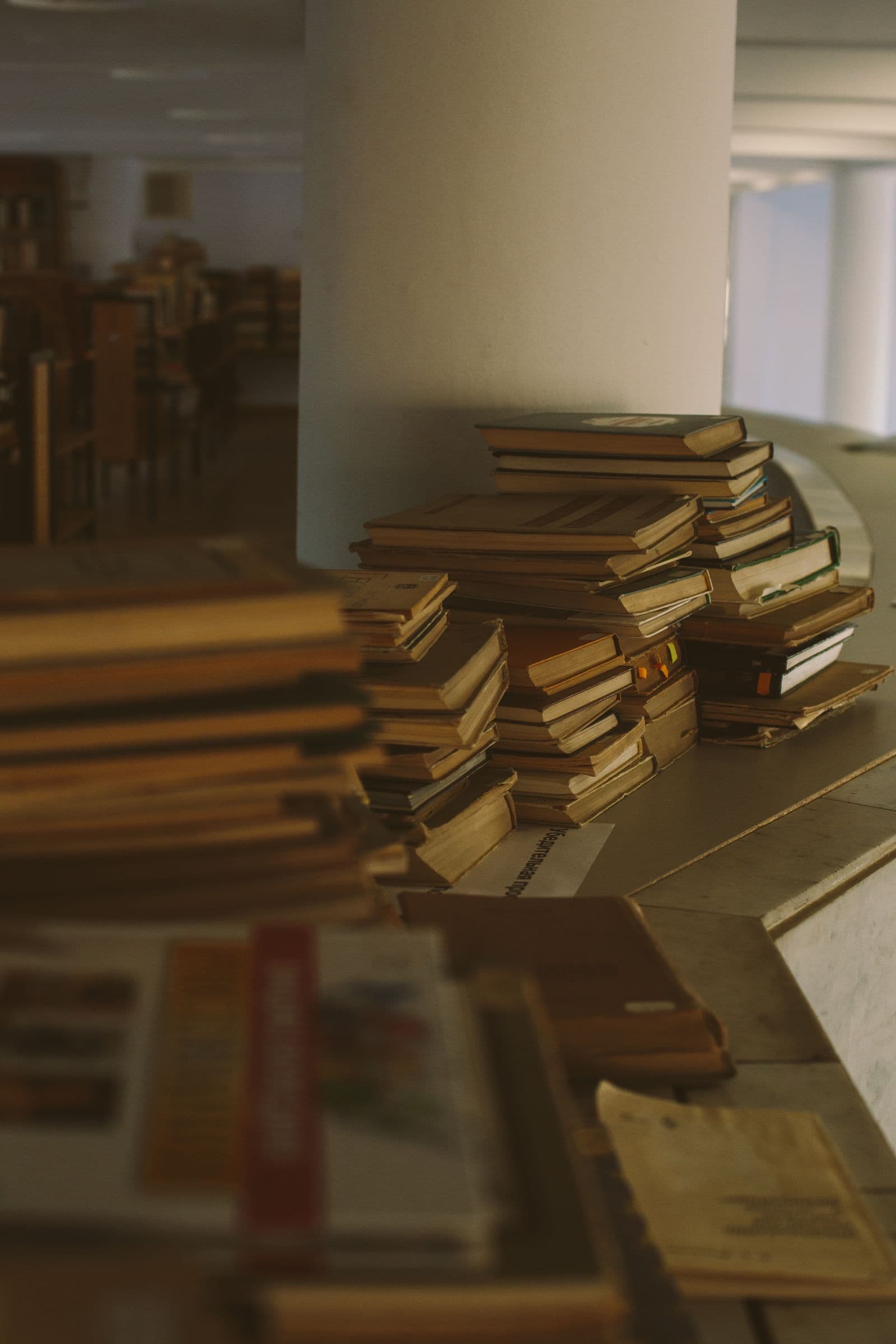Stack of books arranged on a library shelf for study